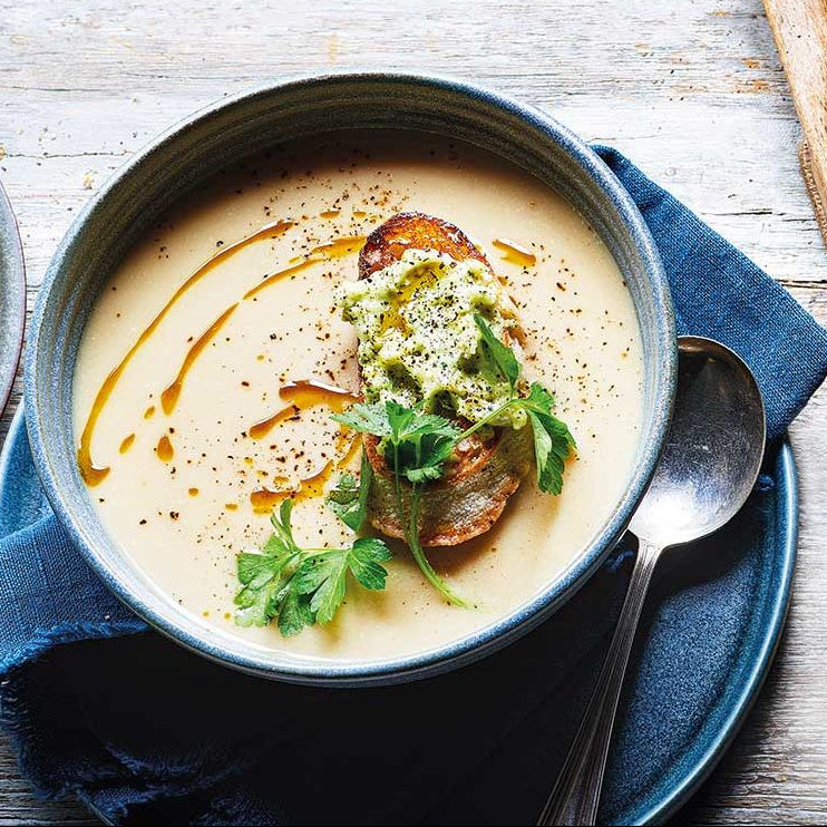 bowl of soup with garnishes on a wooden table