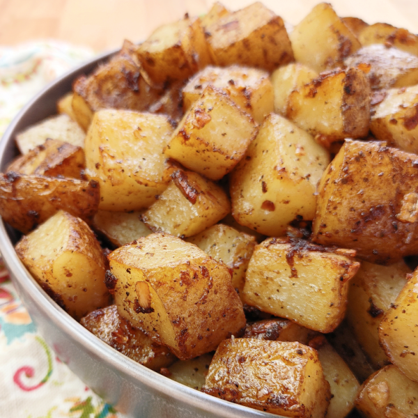 Bowl of roasted potatoes on a patterned tablecloth