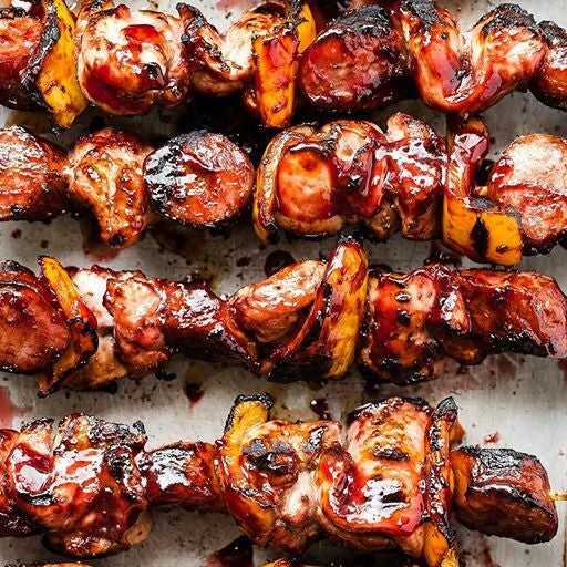 Grilled skewers with sausages and vegetables on a baking sheet